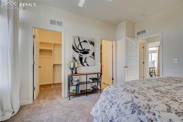 carpeted bedroom featuring a walk in closet and a closet