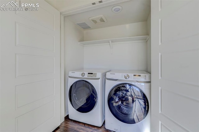 laundry area featuring washer and dryer and dark hardwood / wood-style flooring