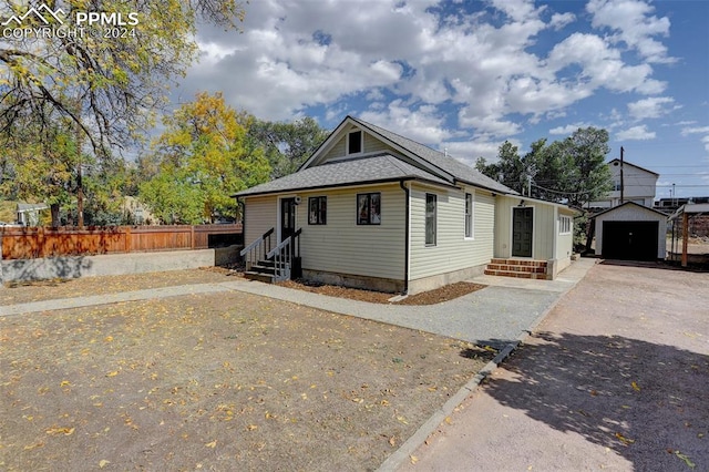 bungalow-style house with a garage and an outbuilding