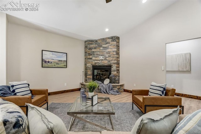 living room featuring a stone fireplace and light hardwood / wood-style flooring