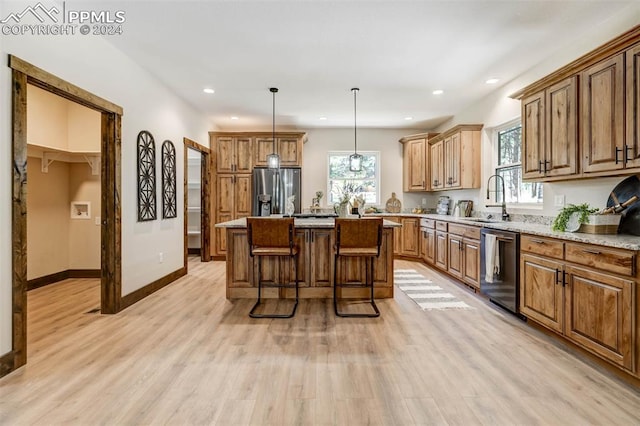 kitchen featuring a center island, stainless steel fridge, sink, pendant lighting, and black dishwasher