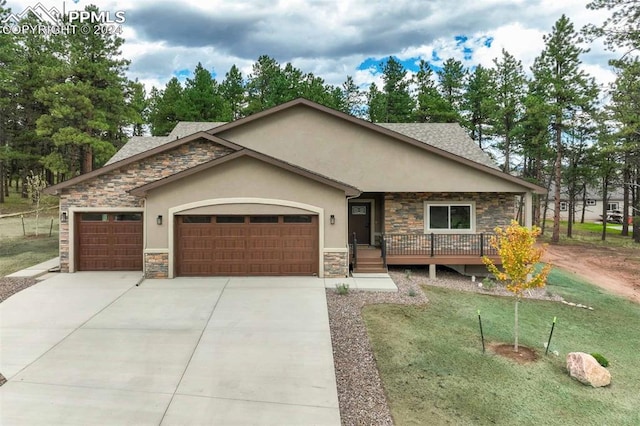 view of front of property with a garage, a front yard, and a deck