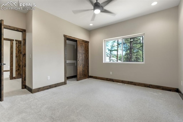 unfurnished bedroom with ceiling fan, a closet, and light carpet