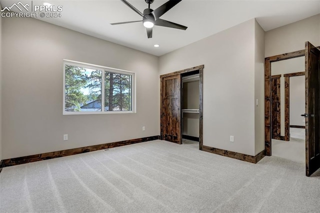 unfurnished bedroom with light carpet, ceiling fan, and a closet