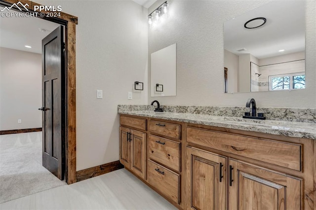 bathroom featuring a shower and vanity