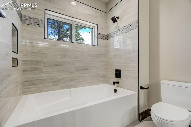 bathroom with tiled shower / bath combo and toilet