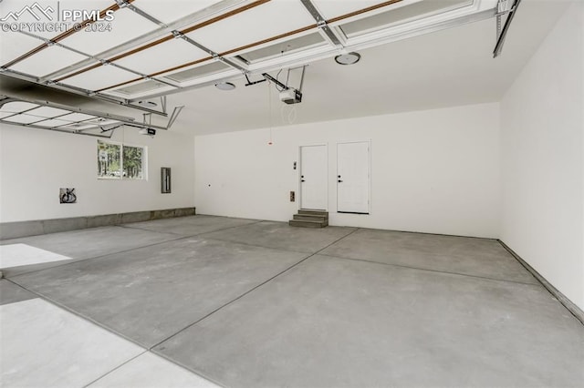 garage with electric panel and a garage door opener