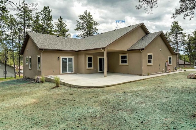 rear view of house with a lawn and a patio area