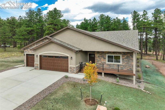 single story home with a garage, a front yard, and a deck