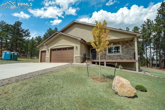 view of front of home featuring a front lawn, a porch, and a garage