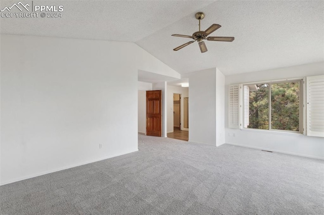 carpeted empty room with vaulted ceiling and ceiling fan