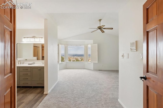 interior space featuring vanity, ceiling fan, vaulted ceiling, and hardwood / wood-style floors