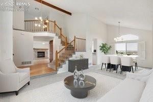 living room with beam ceiling, high vaulted ceiling, and an inviting chandelier