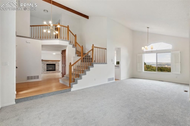 unfurnished living room featuring high vaulted ceiling, an inviting chandelier, and carpet flooring