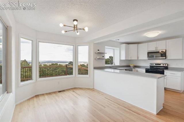 kitchen with a wealth of natural light, sink, appliances with stainless steel finishes, and white cabinets