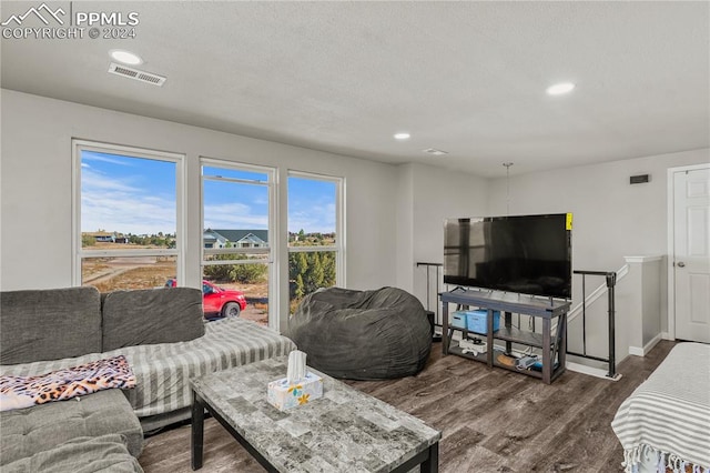 living room with a textured ceiling and dark wood-type flooring