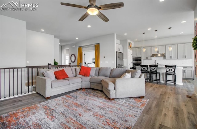 living room featuring ceiling fan and hardwood / wood-style flooring