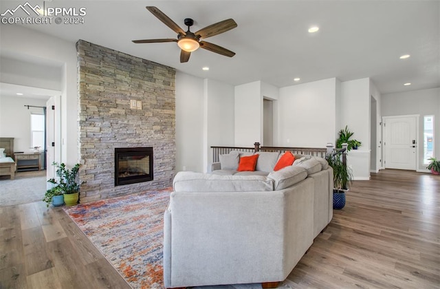 living room featuring light hardwood / wood-style flooring, a fireplace, and ceiling fan