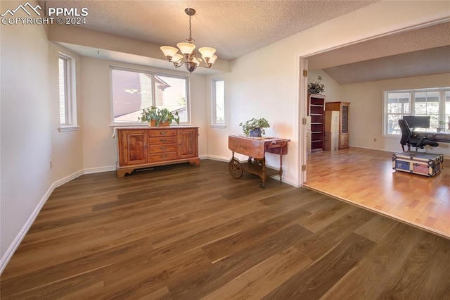 dining space with an inviting chandelier, a textured ceiling, vaulted ceiling, and dark hardwood / wood-style flooring