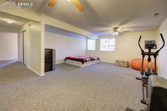 unfurnished bedroom featuring a textured ceiling, heating unit, carpet, and ceiling fan