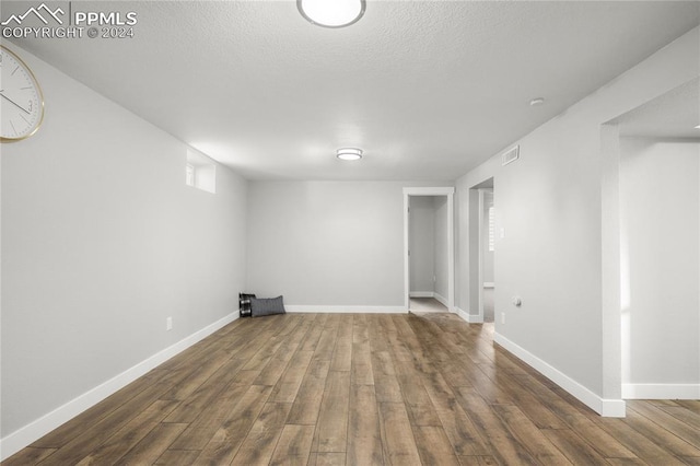 basement with dark hardwood / wood-style flooring and a textured ceiling