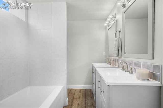 bathroom featuring vanity, backsplash, hardwood / wood-style flooring, and shower / bath combination