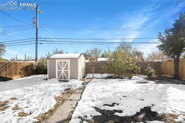 yard covered in snow with a shed