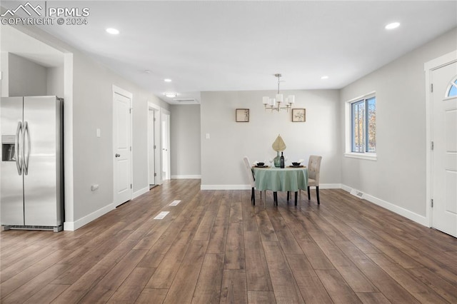 dining space with dark hardwood / wood-style floors and a notable chandelier