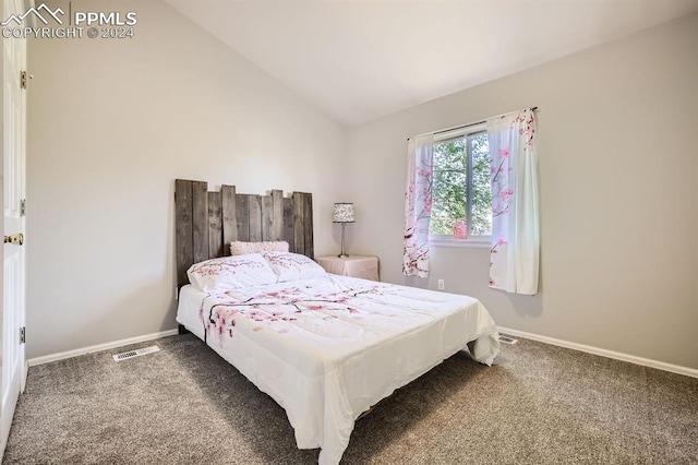 carpeted bedroom with lofted ceiling