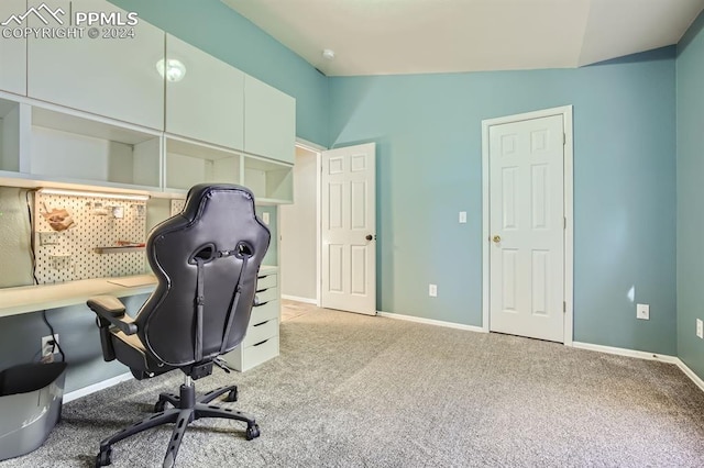 carpeted home office with vaulted ceiling