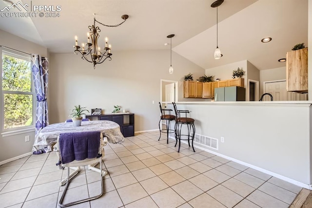 dining area with sink, a notable chandelier, vaulted ceiling, and light tile patterned flooring