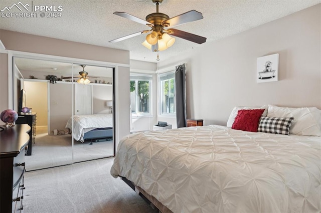 carpeted bedroom featuring a textured ceiling, a closet, and ceiling fan