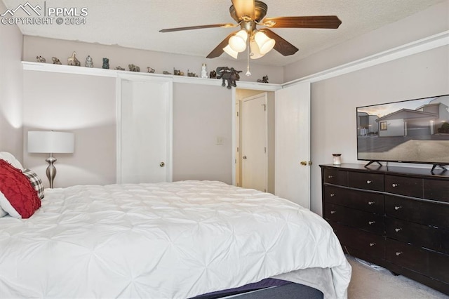 bedroom with ceiling fan, carpet flooring, and a textured ceiling