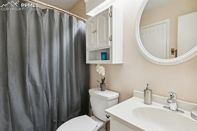 bathroom with vanity, a shower with shower curtain, and toilet