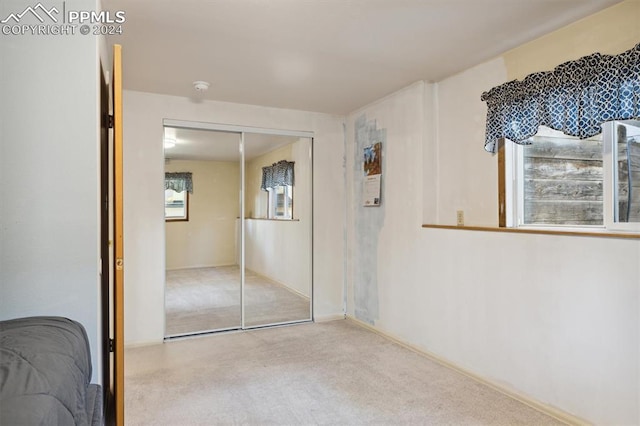 bedroom with light carpet and a closet