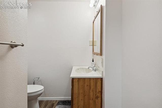 bathroom featuring vanity, toilet, and hardwood / wood-style flooring