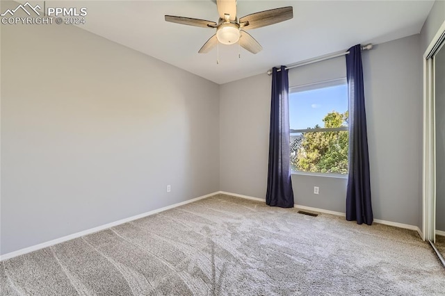 empty room featuring carpet flooring and ceiling fan