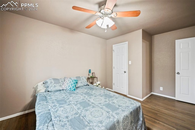 bedroom with dark hardwood / wood-style flooring and ceiling fan