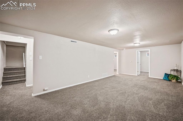 interior space featuring a textured ceiling and carpet floors