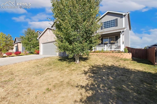 view of front facade featuring a front yard, a porch, and a garage