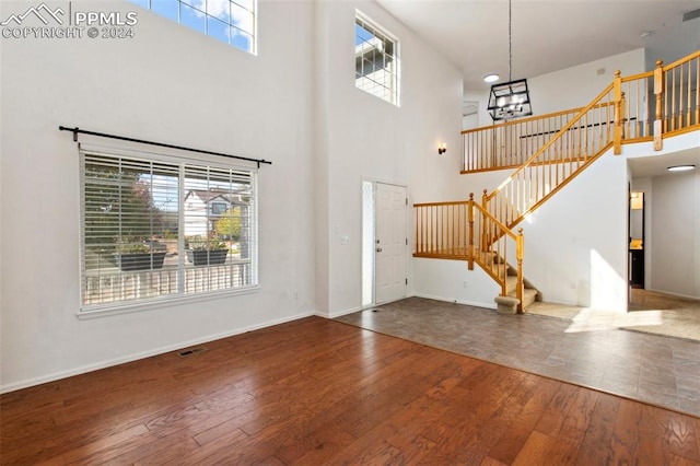 foyer with a healthy amount of sunlight, wood-type flooring, and a high ceiling