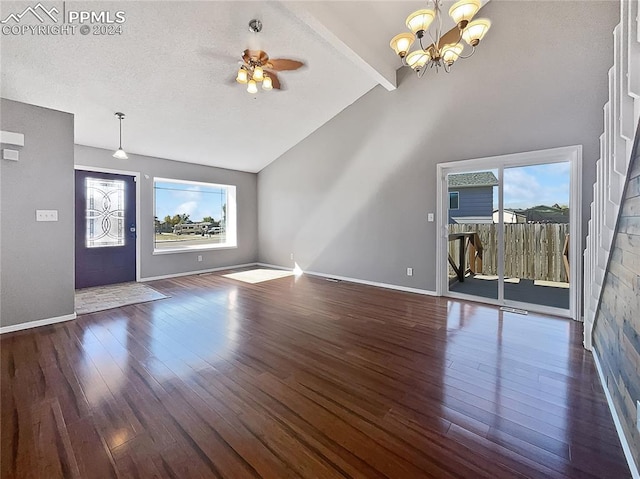 unfurnished living room featuring ceiling fan with notable chandelier, a textured ceiling, dark wood-type flooring, beam ceiling, and high vaulted ceiling