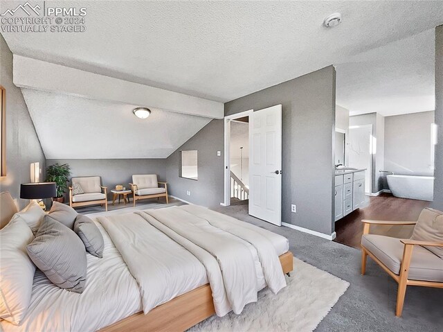 bedroom with vaulted ceiling and a textured ceiling