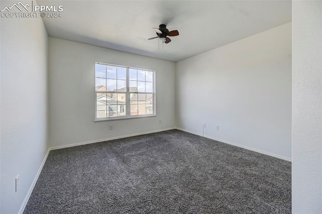 spare room featuring dark colored carpet and ceiling fan