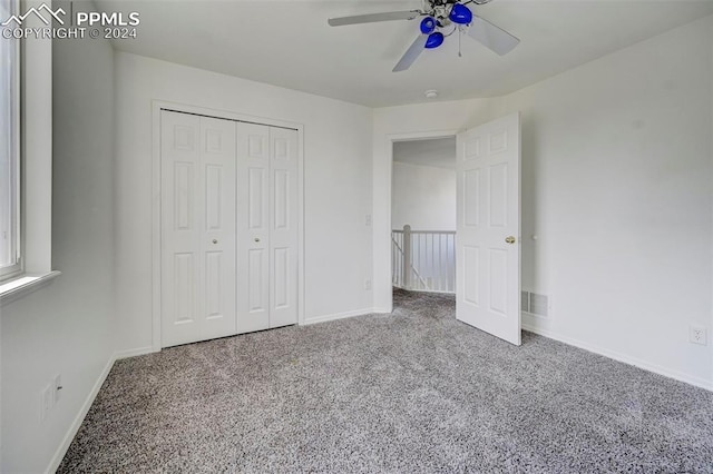 unfurnished bedroom featuring carpet floors, a closet, and ceiling fan