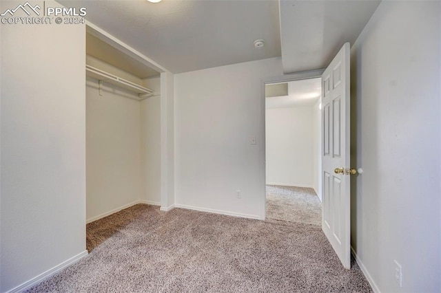 unfurnished bedroom featuring a closet and light colored carpet