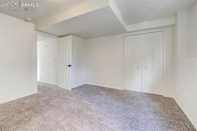 unfurnished bedroom with a closet and light colored carpet