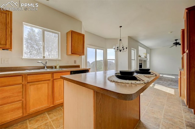 kitchen with a kitchen island, a healthy amount of sunlight, sink, and hanging light fixtures