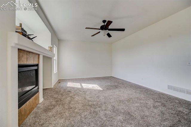 unfurnished living room featuring ceiling fan, a fireplace, and carpet