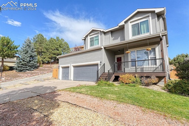 view of front of home featuring a porch, a front lawn, and a garage